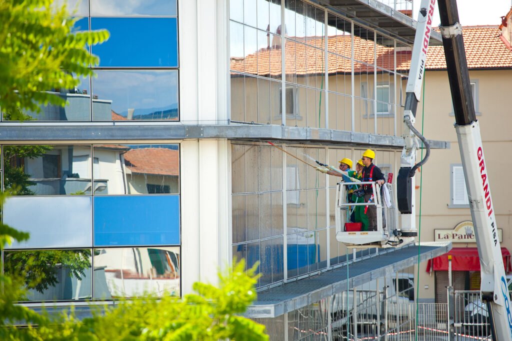 Empoli, Italy - 17 May 2016: Window cleaner working on a glass facade of the building. Cleaning Maintenance of USL 11 in Dei Cappuccini street in Empoli.